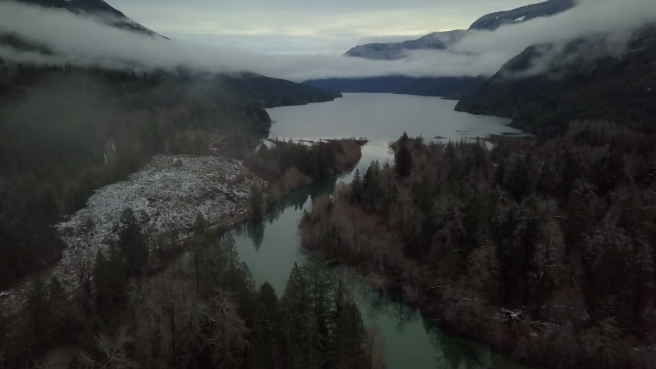 Ripresa aerea inclinata e nuvolosa di una valle invernale con fiume e montagne sull'isola di Vancouver, Canada