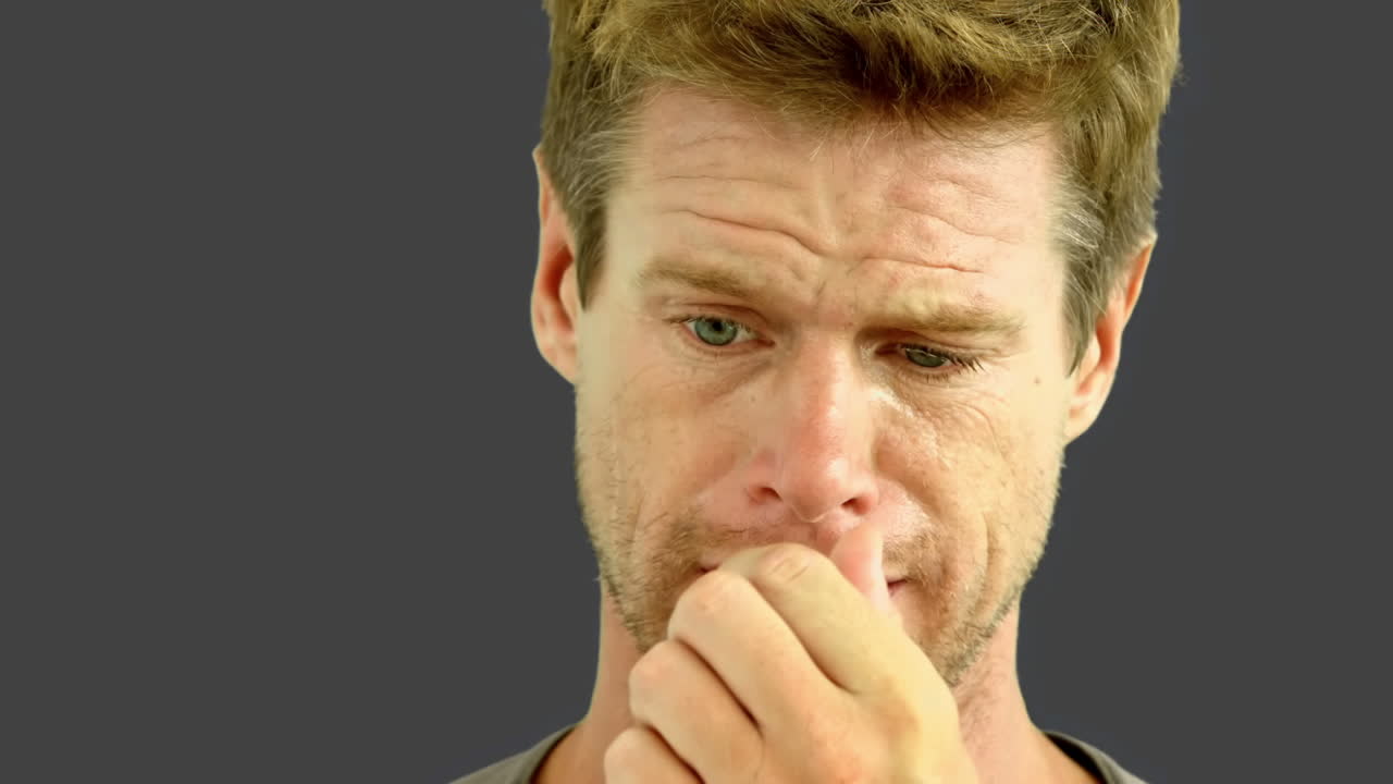 Uomo che piange su schermo grigio
