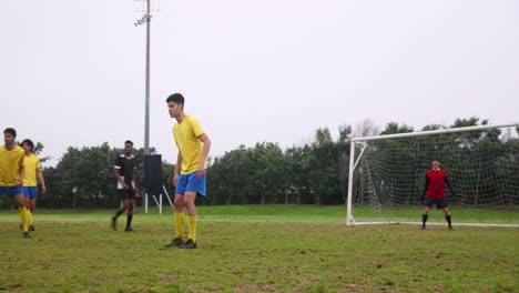 playing soccer on field, boys in yellow jerseys focusing on game
