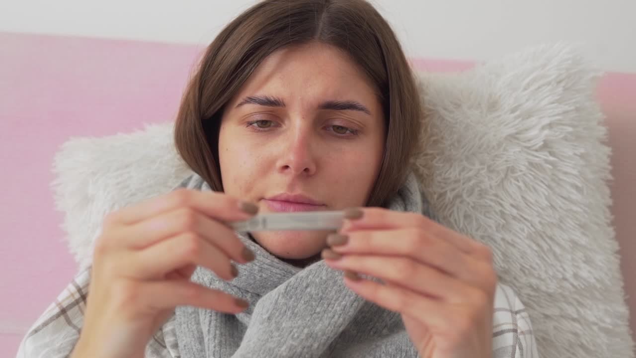 больная девочка лежит в постели, кашляет и сопит, девочка измеряет температуру и шокирована увиденным