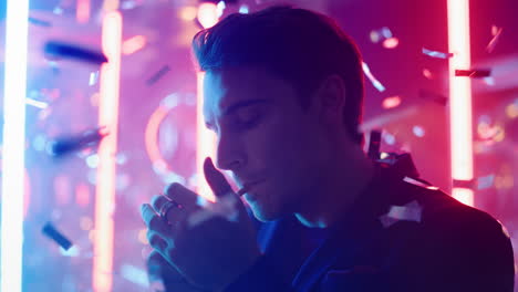 thoughtful guy smoking in nightclub. serious man lighting cigarette at party