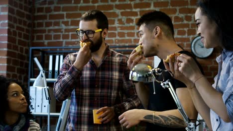 colegas en la oficina comiendo pizza juntos