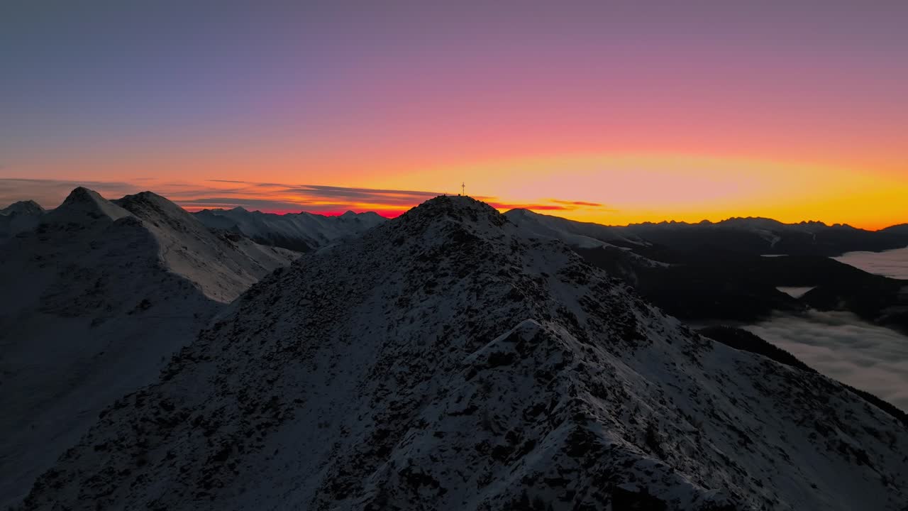 Dawn's light graces snowy peaks in Northern Italy, captured by drone