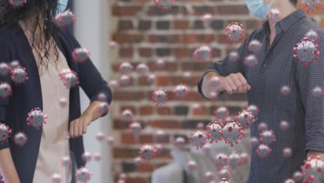 animation of covid 19 cells floating over people in face masks, touching elbows in office