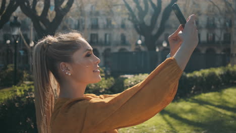 una giovane donna elegante che scatta foto all'aperto.