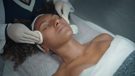 handen schoonmaken gezicht pads in een schoonheidssalon. close-up schoonheidsspecialist vegen gladde huid
