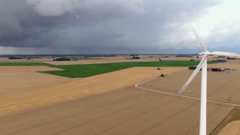 Dolly-Drohne-Aufnahme-Von-Weiten-Feldern-In-Südschweden-Mit-Windkraftanlage-Im-Vordergrund