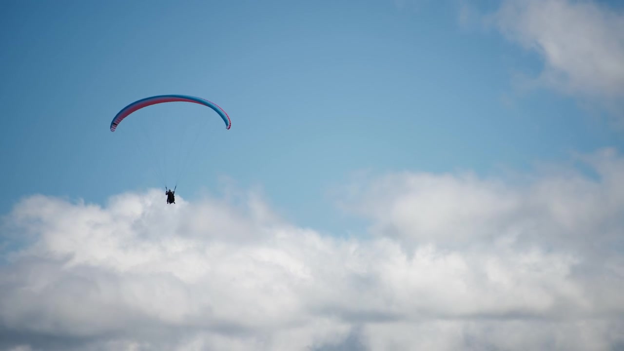 Fallskjermhopper mot himmel og skyer