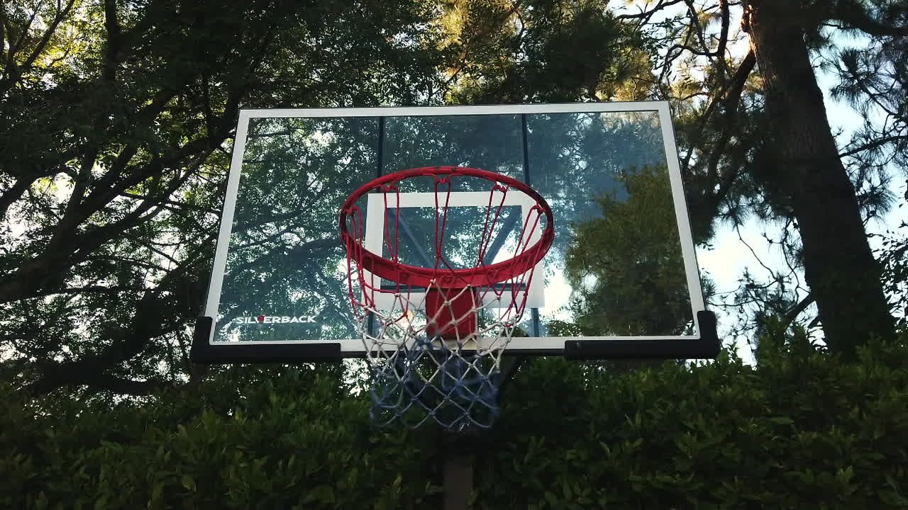 tres tiros en salto consecutivos en cámara lenta moviéndose a través de la canasta a 4k 60fps