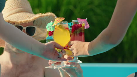 amigos brindando por las bebidas en la piscina.