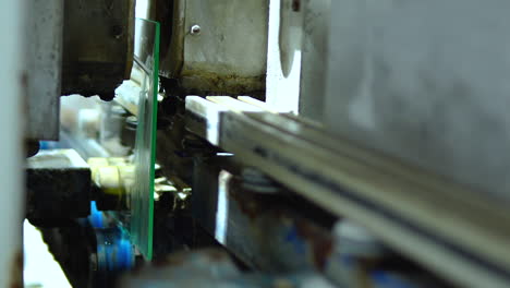 sheets of glass passing through auto drilling machines during their processing at the glass manufacturing industry