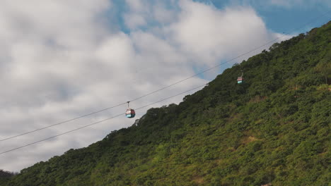 Cable-cars-or-Gondolas-moving-up-a-green-mountainside-in-Salta,-Argentina