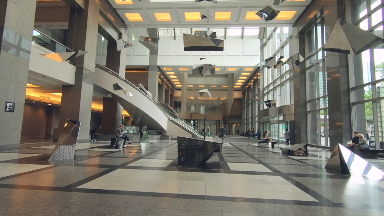 view of interior beautiful modern contemporary architecture, hall of office building, beautiful decor lights , ceiling, people in the hall. sky and skyscraper view up through the glass window.