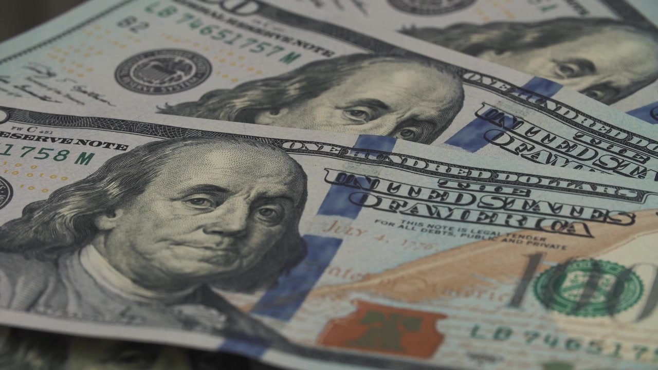 Vista detalhada de notas de 100 dólares americanos espalhadas