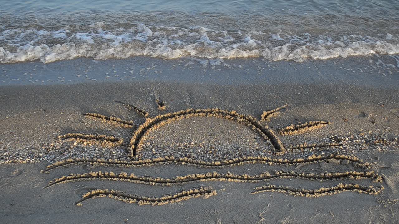 Drawing on sand. Drawing of waves and hot summer sun on golden beach sand conceptual of a summer vacation on a tropical beach