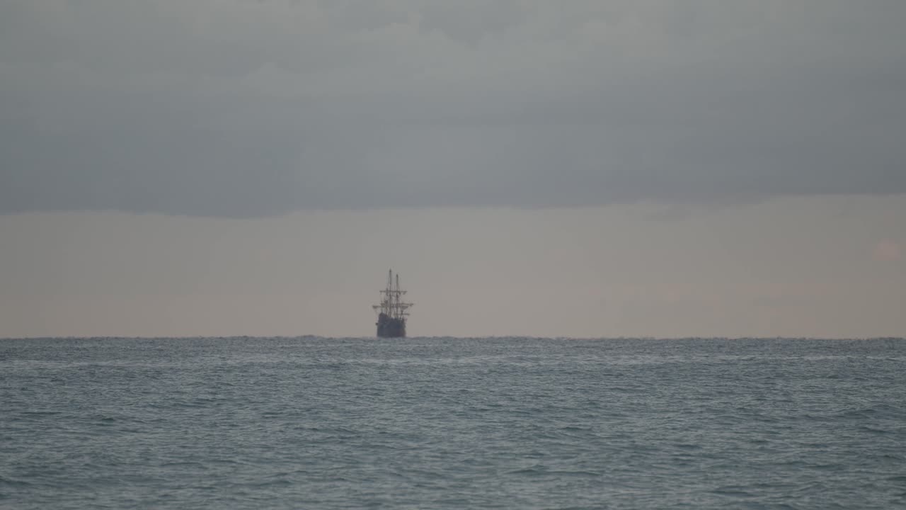 16세기 갤리온 안달루시아 복제선은 해가 뜰 때 어둡고 흐린 날 지중해에서 먼 거리를 항해합니다.