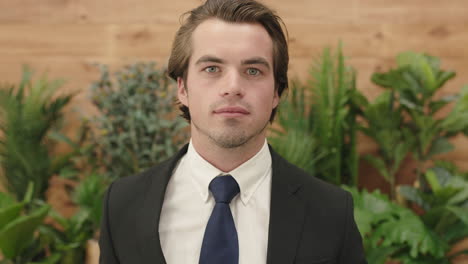 attractive young business man portrait of sales person wearing suit running hand through hair looking confident at camera