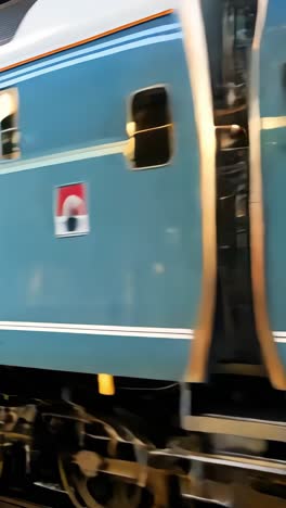 blue passenger train arriving at station platform during evening hours