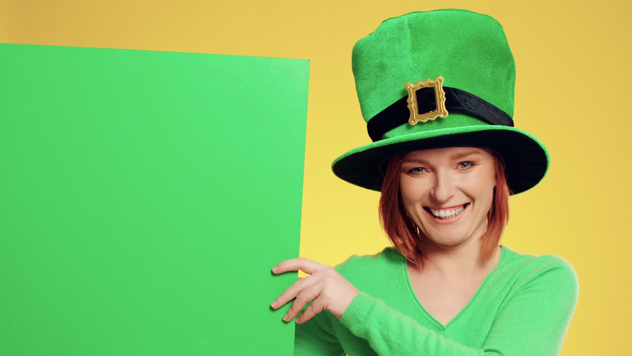 Portrait of woman with leprechaun's hat pointing at banner