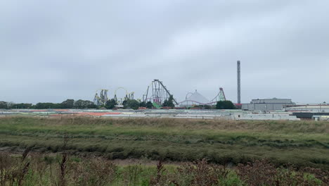 A-roller-coaster-in-the-distance-at-an-amusement-theme-park-with-rides