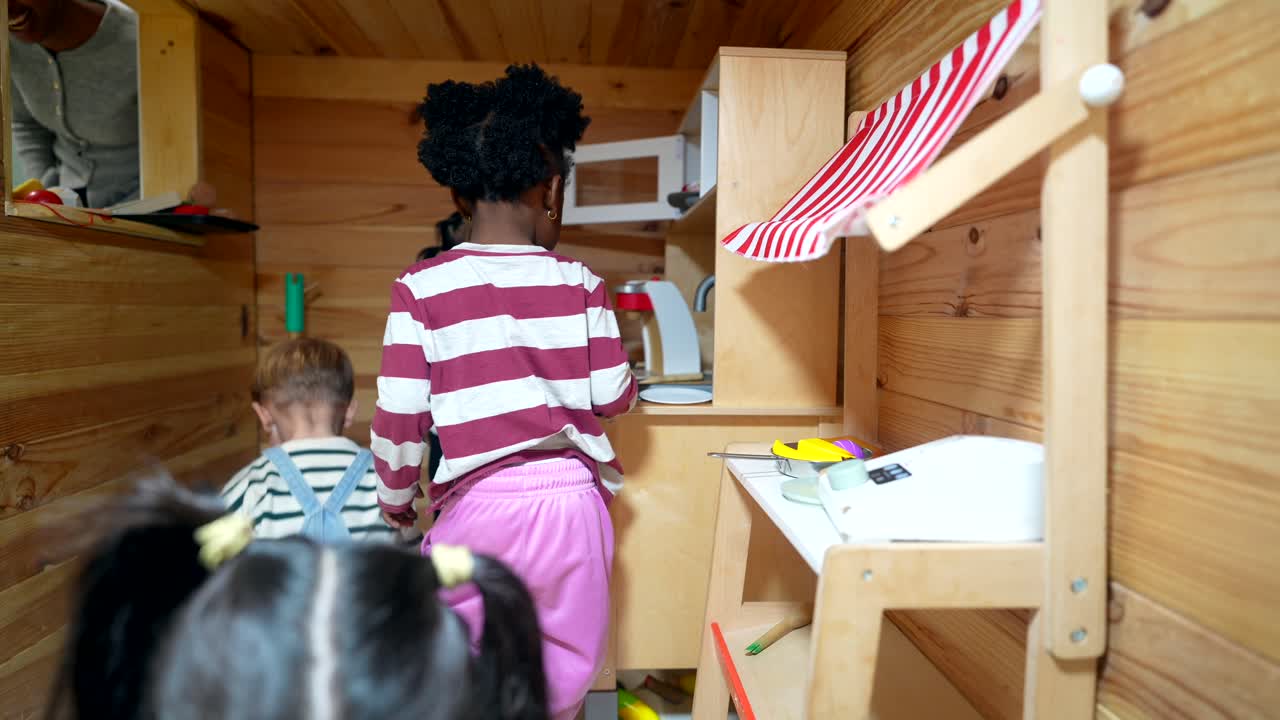 Diverse Children Playing with Toy Kitchen in Wooden Playhouse