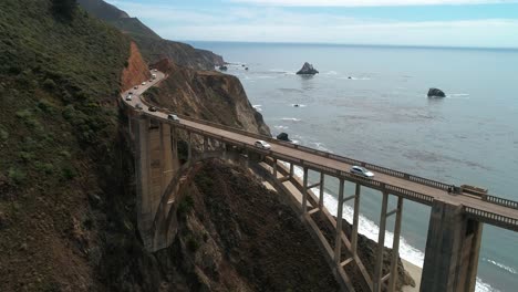 video aéreo de drones de la carretera del puente bixby con agua y costa debajo en big sur monterrey california