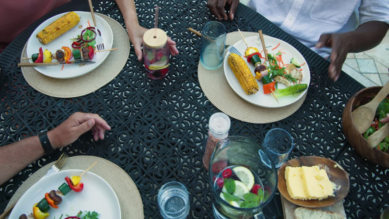 Enjoying in garden meal with fresh salad, grilled corn, and crusty bread