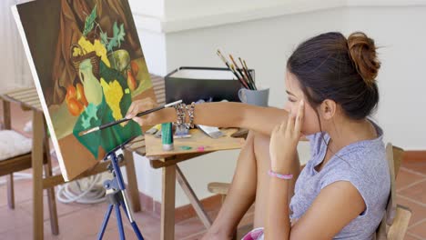 young woman artist painting a flower still life