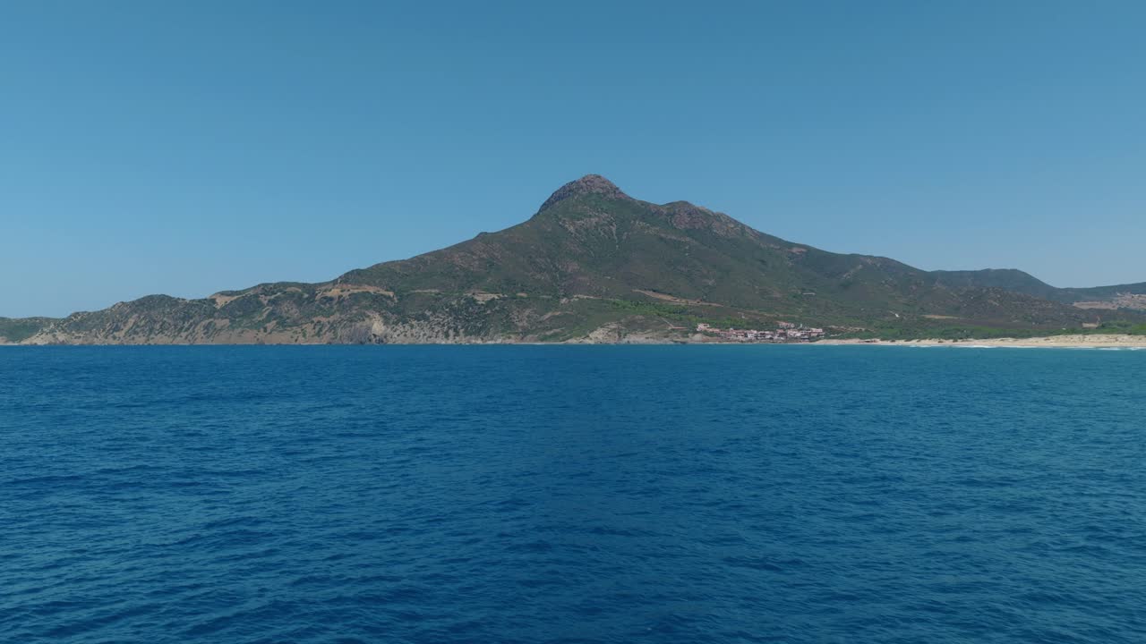 Calm Sardinian coastline with deep blue sea and distant hills