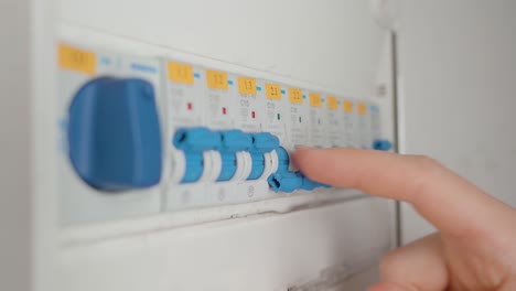 man flipping the circuit breaker switches to their off position