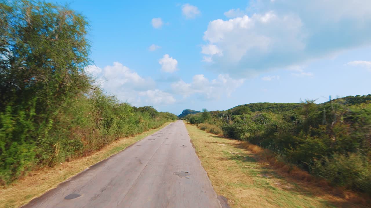 Percorrendo una strada rurale dissestata e rattoppata a Curaçao, Caraibi.