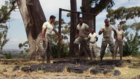 tropas militares corriendo sobre neumáticos durante el obstáculo 4k