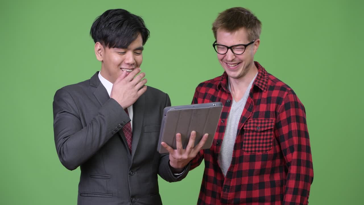 젊은 잘생긴 아시아 사업가와 젊은 스칸디나비아 사업가가 함께 일하고 있습니다.