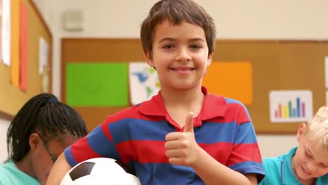 Niño-Con-Los-Pulgares-Hacia-Arriba-Sosteniendo-Una-Pelota