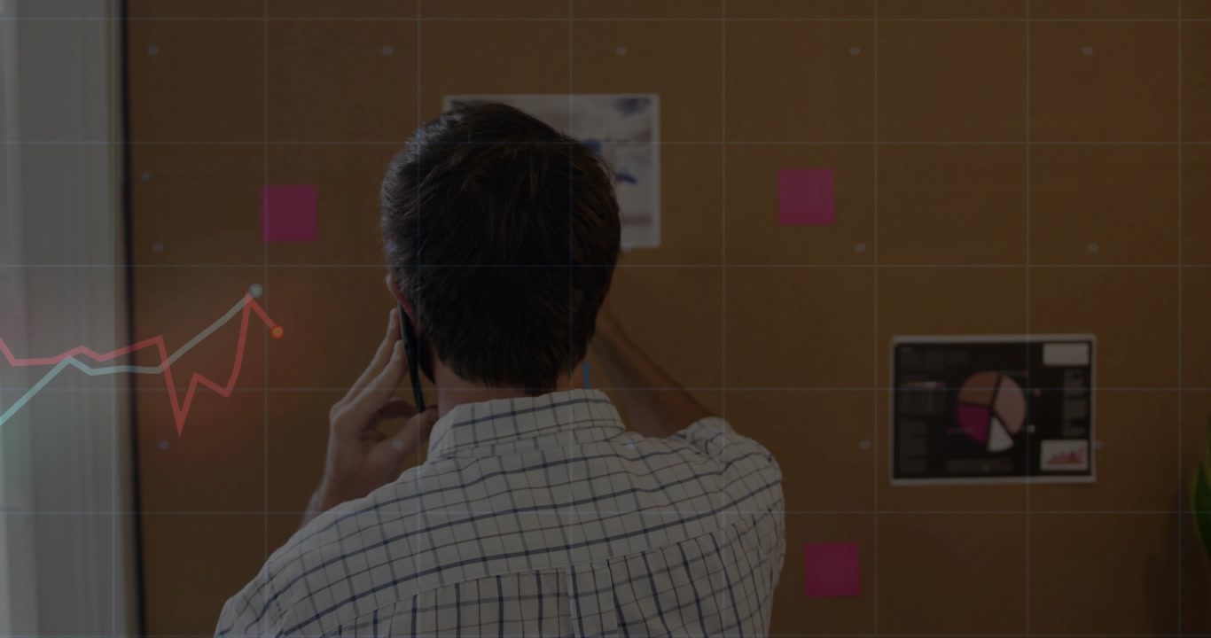 man raising smartphone to ear making business call while pointing pie chart and monitoring graphs