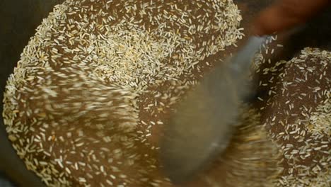 close up of frying rice with sand in a pan