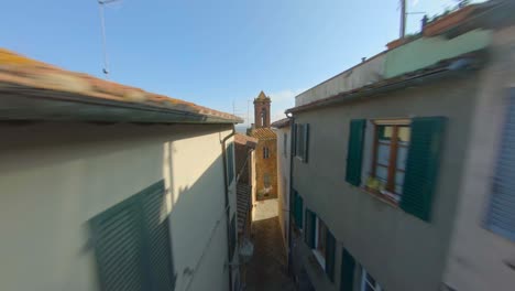 FPV-drone-view-among-the-narrow-streets-of-an-Italian-village-in-Tuscany