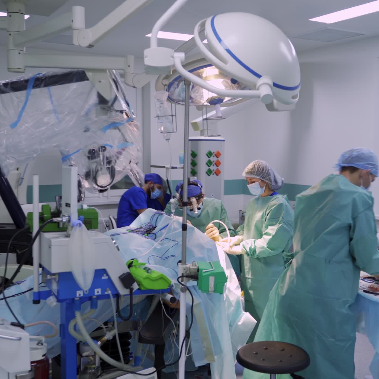 Big surgical room full of advanced technique in modern clinics. Team of surgeons performing operation in the middle of the operational ward