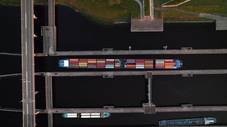 Containership Under Channels Of Krammerbrug Bridge In The Netherlands. Aerial Topdown Shot
