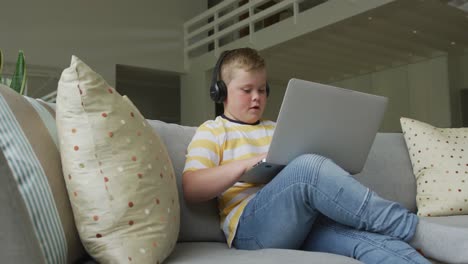 Kaukasischer-Junge-Sitzt-Im-Wohnzimmer-Und-Benutzt-Allein-Zu-Hause-Einen-Laptop