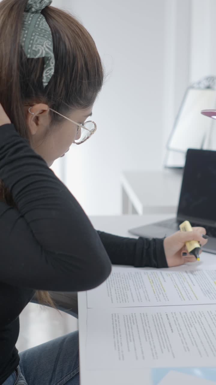 Woman highlighting documents while studying