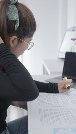 woman highlighting documents while studying