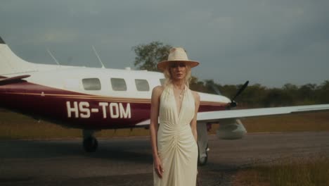 woman in a dress standing next to a private jet
