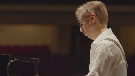 pianist playing piano on stage during recital