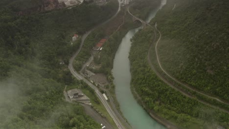 aerial view of a mountainous valley with river, bridge, and road