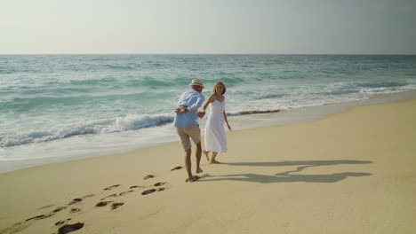 Feliz-Pareja-Joven-Divirtiéndose-En-La-Playa-De-Arena