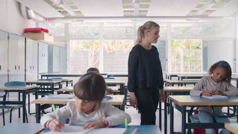 female school teacher walking between pupils