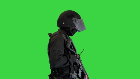 swat operator with assault rifle walking on a green screen, chroma key
