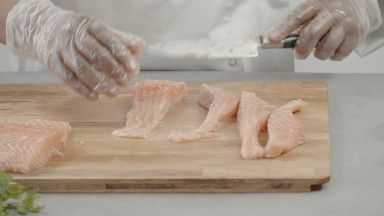 close up of chef's hand cutting chicken. Man cutting fresh meat with knife on wooden cutting board. cooking concept