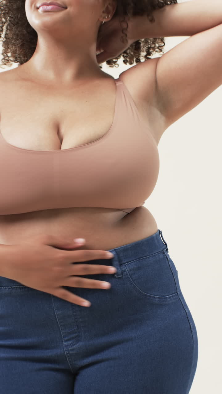Video verticale: Donna curvy sorridente in abbigliamento casual in posa con sicurezza, che abbraccia la positività corporea